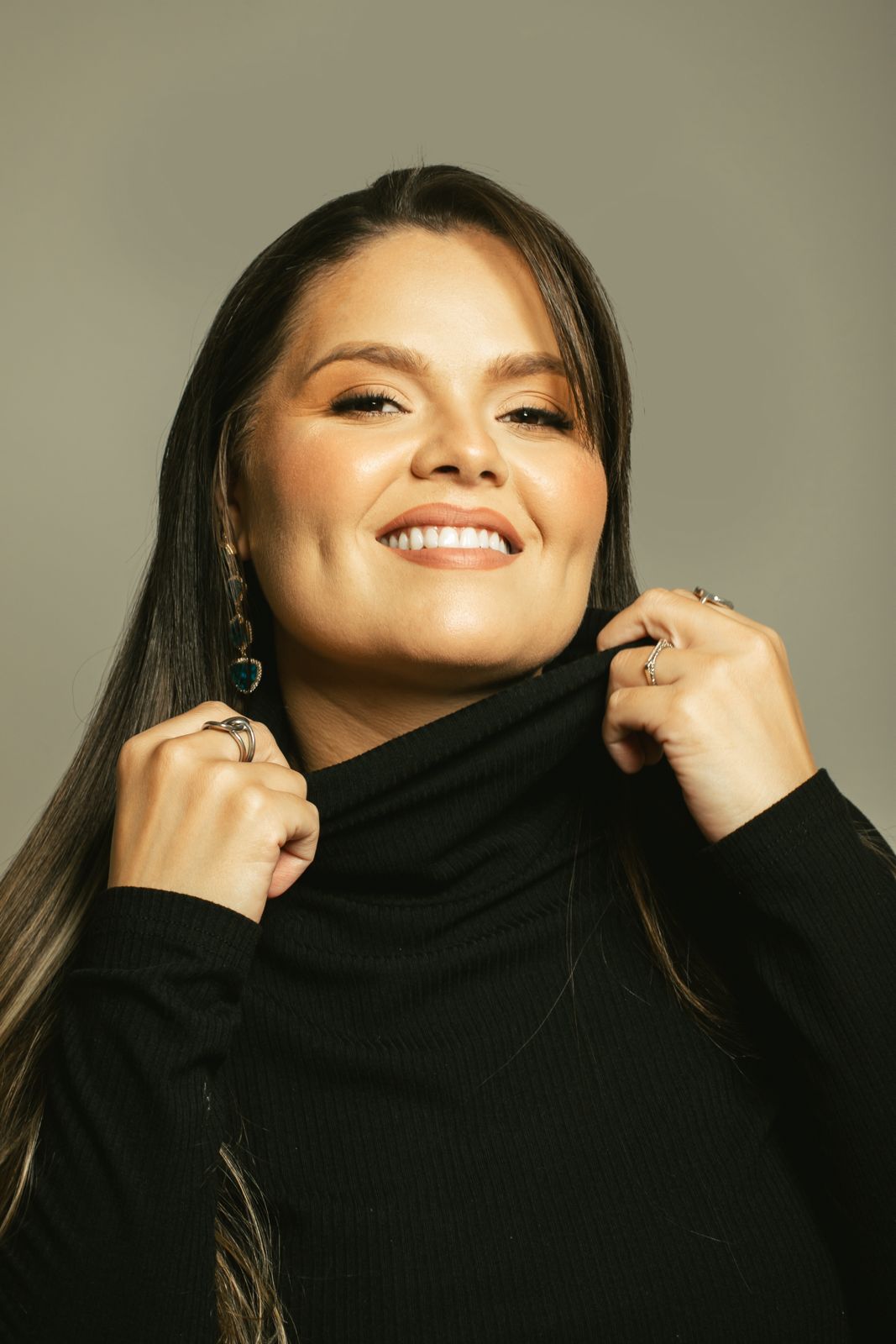Dra. Tathyane Amorim sorrindo, com gola alta preta
